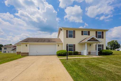 A two-story house with a garage and a driveway.