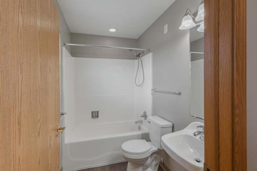 A white bathroom with a toilet, sink, and bathtub.