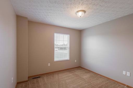 A room with a window and a ceiling light.