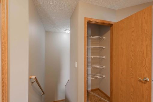 A small kitchen with a wooden door and a refrigerator.