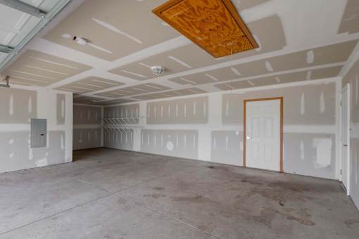 A room with a wooden ceiling and walls covered in drywall.