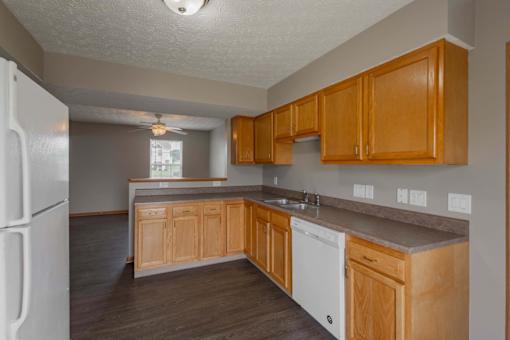 A kitchen with wooden cabinets and a white refrigerator.