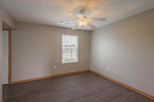 Empty room with a ceiling fan and a window.
