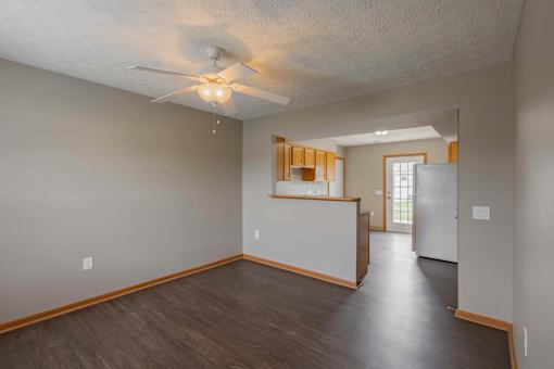A room with a ceiling fan and wooden flooring.