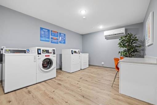 A laundry room with washing machines and a dryer.