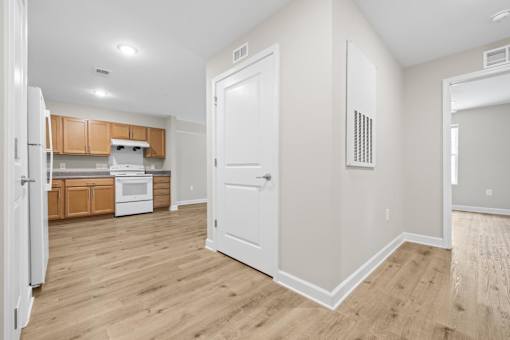 A kitchen with wooden floors and white walls.