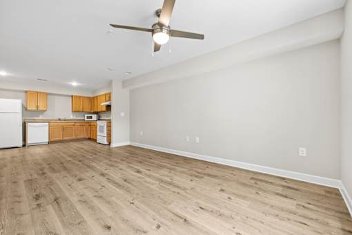 A room with a ceiling fan and wooden flooring.