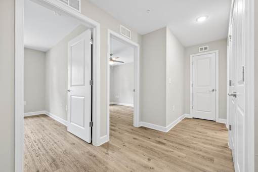 A room with white doors and wooden floors.