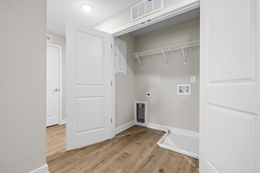 A small room with a white door and a white cabinet above it.