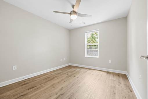 A room with a ceiling fan and a window.