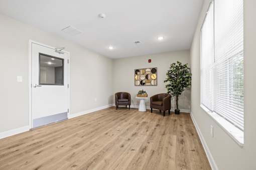 A living room with a brown chair and a small table with a plant on it.