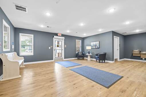 A spacious room with wooden floors and a variety of exercise equipment.