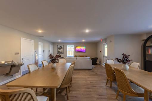 A dining room with a long wooden table and chairs.
