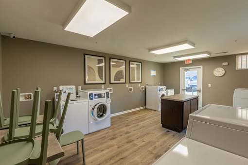 A laundry room with a washer and dryer, a washing machine, a cabinet, and a wash basin.