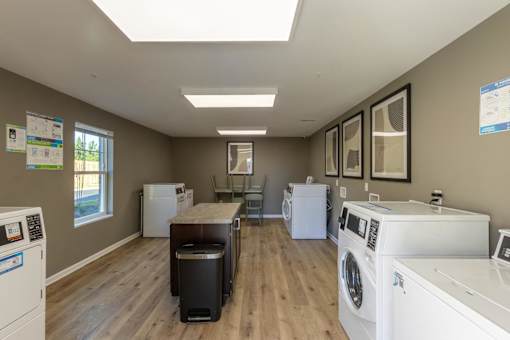 A laundry room with a washer and dryer on the right and a washing machine on the left.