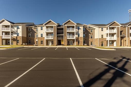 A parking lot in front of apartment buildings.