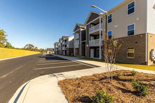 A row of modern apartment buildings with a clear blue sky above.