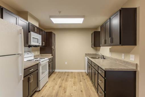 A kitchen with brown cabinets and a white fridge.