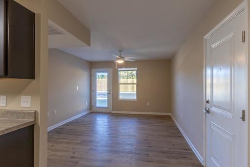 A room with wooden floors and a window with blinds.