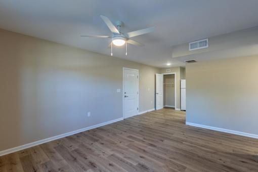 A room with a ceiling fan and light fixture.