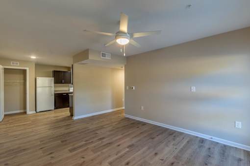 A room with a ceiling fan and wooden flooring.