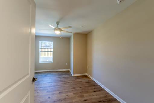 A room with a ceiling fan and a window.