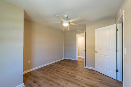A room with a ceiling fan and two doors.