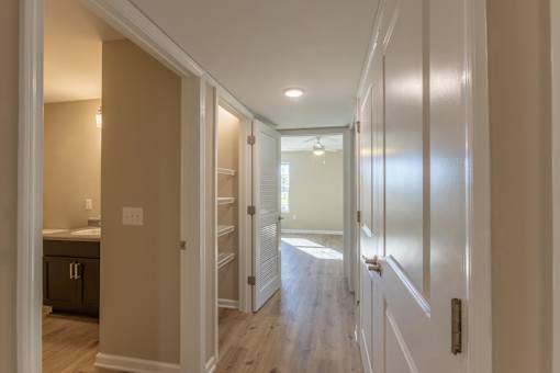A hallway with white doors and a light on the wall.