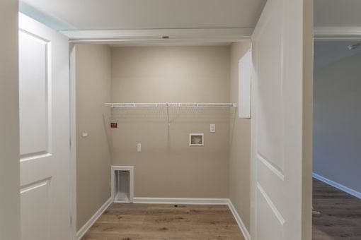 A room with a white door and a white closet with a white shelf.