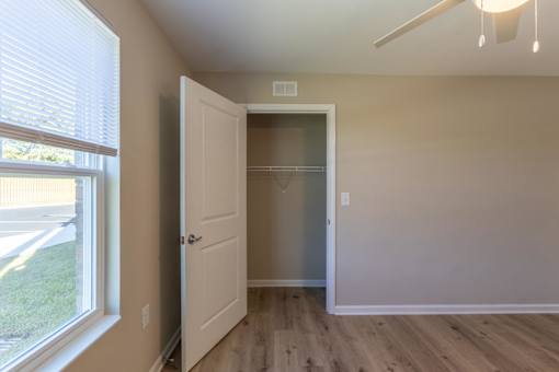A room with a white door and a window with blinds.