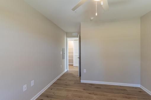 A long, empty hallway with a door at the end.