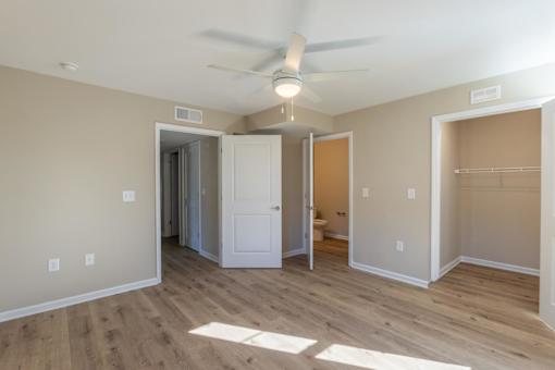 A room with a ceiling fan and a doorway leading to another room.