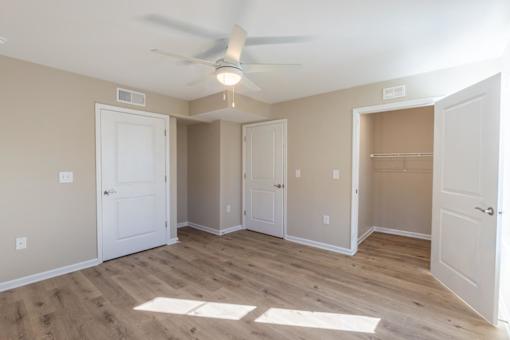 A room with a ceiling fan and wooden flooring.