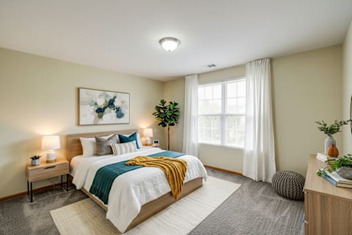 A bedroom with a bed, nightstands, and a window.