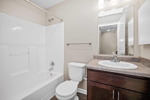 a bathroom with a toilet sink and shower and a mirror