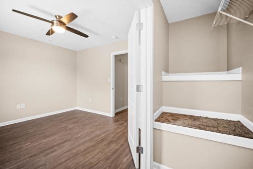 an empty bedroom with a ceiling fan and a closet