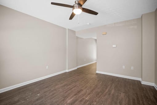 a living room with wood floors and a ceiling fan