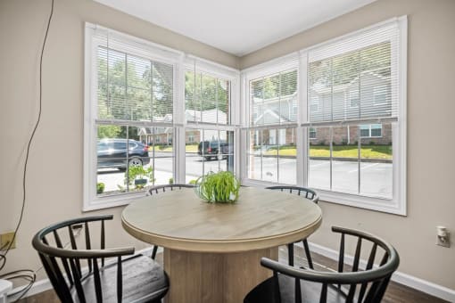 a dining room with large windows and a table with chairs