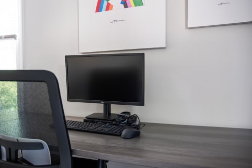 a computer monitor and keyboard on a wooden desk