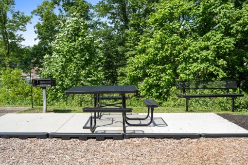 two picnic tables with benches in a park