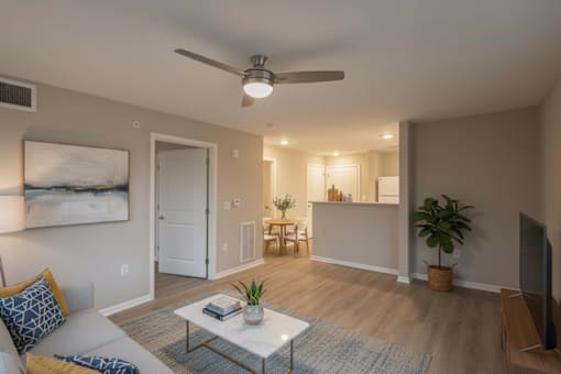 A living room with a couch, a coffee table, and a ceiling fan.