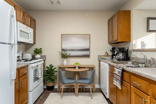 A kitchen with a white refrigerator, wooden cabinets, and a painting on the wall.