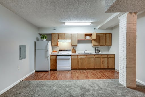 A kitchen with wooden cabinets and a white refrigerator.