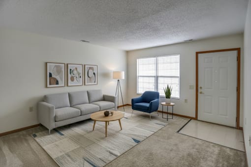 A living room with a grey couch, blue chair, and a coffee table.
