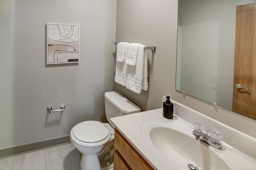 A bathroom with a toilet, sink, and a towel hanging on the towel rack.