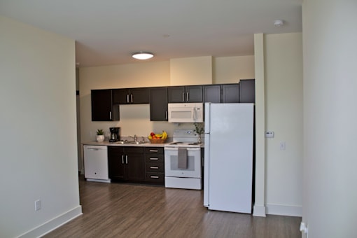 A kitchen with black cabinets and white appliances.