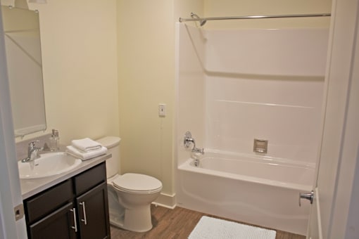A white bathroom with a toilet, sink, and bathtub.