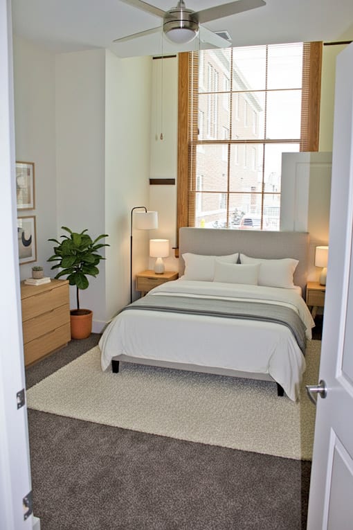 A bedroom with a large bed and a ceiling fan.