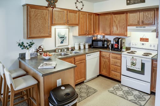 A kitchen with wooden cabinets and a white stove top oven.