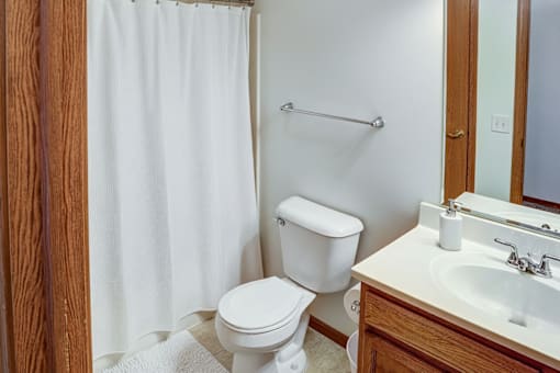 A white toilet sits next to a white sink in a bathroom.